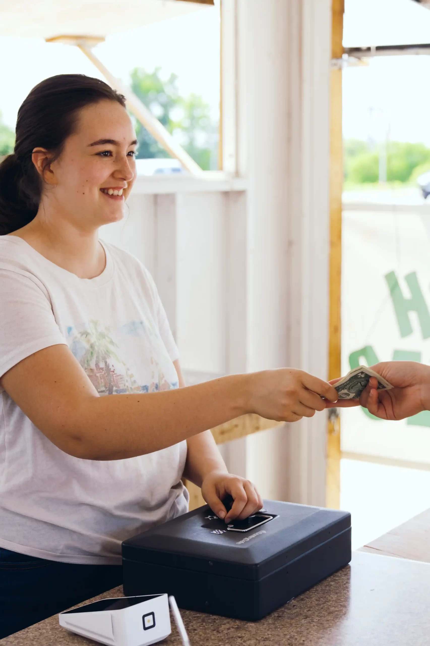 Happy Employee Handing Cash To Customer Happy Employee Handing Cash To Customer 1 scaled